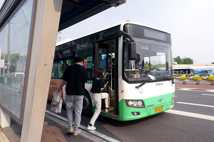  Residenti salgono su un autobus nel distretto di Fengxian, a Shanghai. (16 maggio 2022 - Gao Erqiang/China Daily)