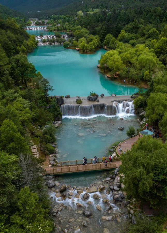 Turisti visitano la Valle della Luna blu ai piedi della montagna innevata Yulong nella città di Lijiang, nella provincia dello Yunnan, nel sud-ovest della Cina. (26 giugno 2022 - Xinhua/Jiang Wenyao)