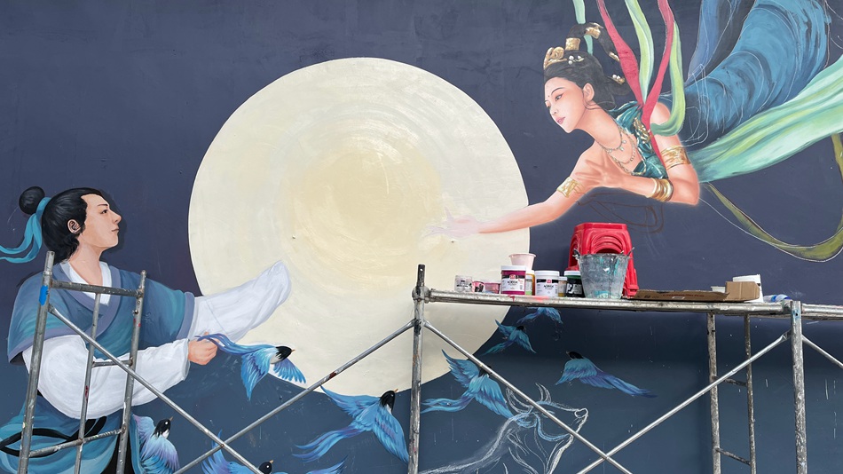 Giovane artista decora le pareti di un villaggio dello Yunnan con vivaci dipinti