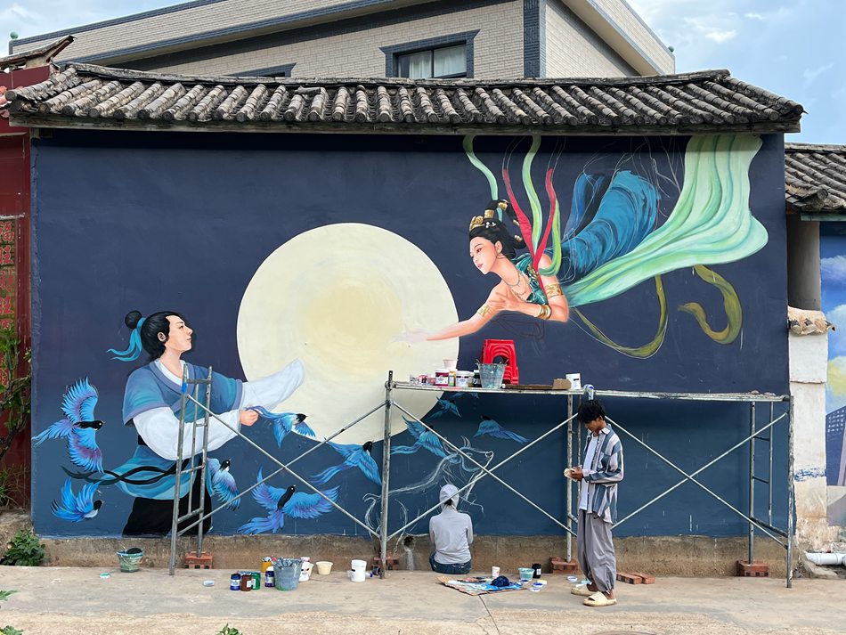Giovane artista decora le pareti di un villaggio dello Yunnan con vivaci dipinti