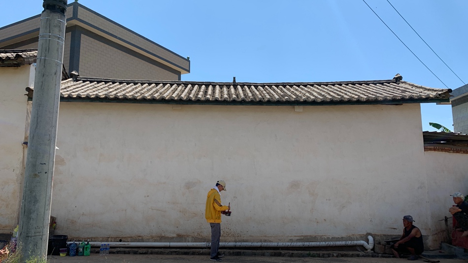 Giovane artista decora le pareti di un villaggio dello Yunnan con vivaci dipinti