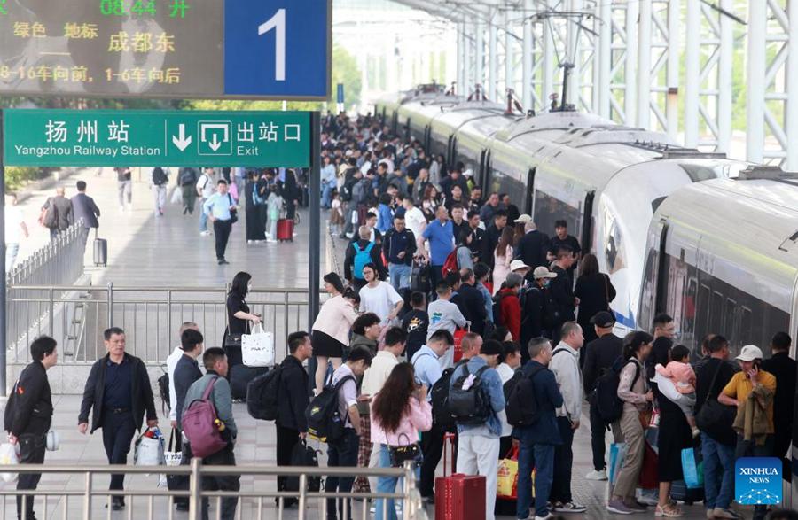 Passeggeri salgono su un treno alla stazione ferroviaria di Yangzhou, nella provincia orientale cinese del Jiangsu. (29 aprile 2025 - Xinhua/Meng Delong)