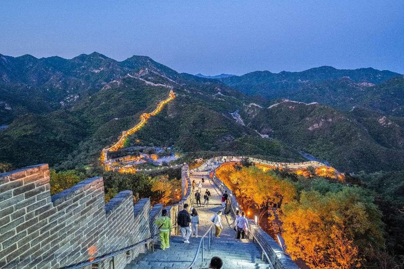Turisti si godono il panorama notturno sul tratto Badaling della Grande Muraglia. (30 aprile 2025 - Quotidiano del Popolo Online/Luo Dafu)