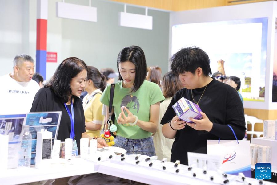 Un'espositrice (prima a sinistra, in primo piano) promuove i suoi prodotti ai visitatori durante la 31a edizione della China Lanzhou Investment and Trade Fair a Lanzhou, nella provincia del Gansu, Cina nord-occidentale. (6 luglio 2025 - Xinhua/Zhang Zhimin)