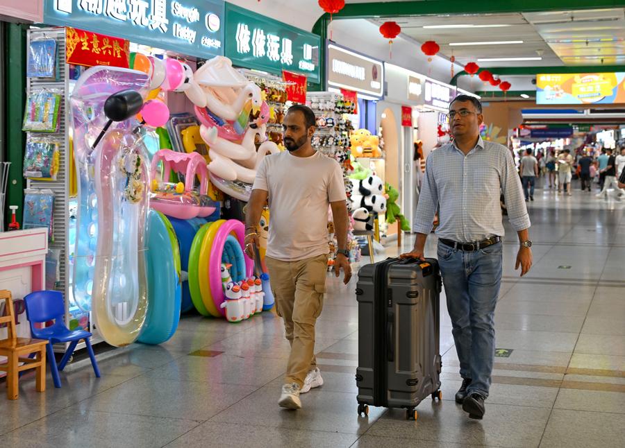 Stranieri con una valigia per l'acquisto di campioni al mercato commerciale internazionale di Yiwu, nella provincia dello Zhejiang, Cina orientale. (16 maggio 2025 - Xinhua/Chen Shuo)
