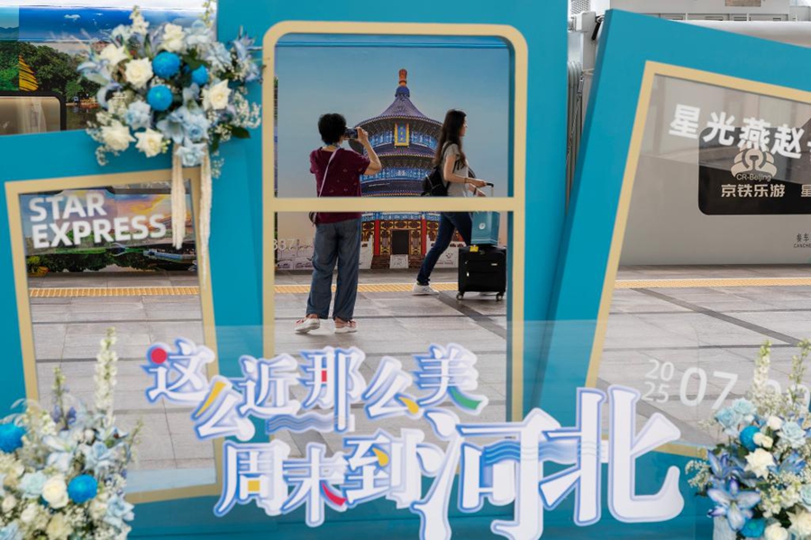 Un passeggero scatta foto a un treno turistico panoramico diretto a Chengde, presso la Stazione Ferroviaria di Beijing. (9 luglio 2025 - Xinhua/Bai Xuefei)