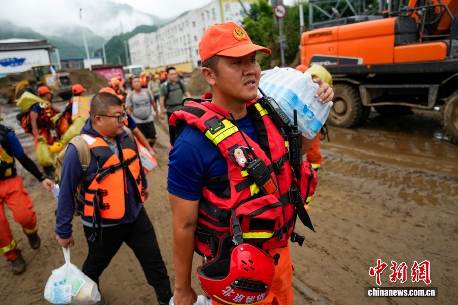 Vigili del fuoco trasportano a piedi i beni di soccorso. (28 luglio 2025 – China News/Zhao Wenyu)