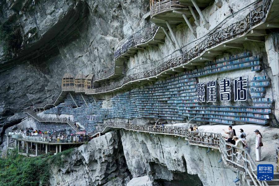 Turisti visitano la libreria sulla scarpata nell'area panoramica del Tiankeng di Mianhua, nella città di Hechi, Guangxi. (10 agosto 2025 – Xinhua/Long Tao)