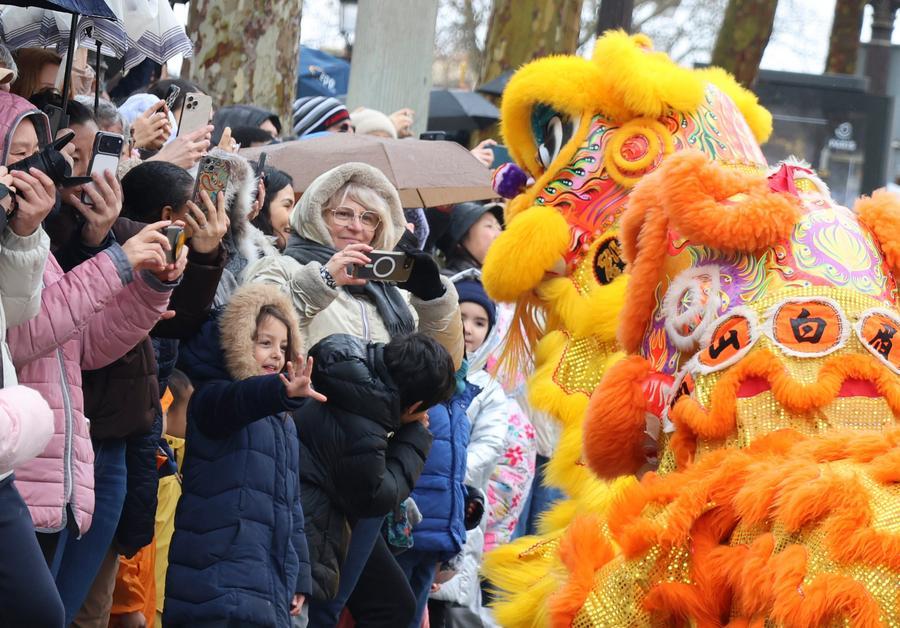 Persone assistono a uno spettacolo di danza del leone durante una parata per celebrare l'imminente Capodanno cinese sul viale degli Champs-Élysées a Parigi, in Francia. (1 febbraio 2026 - Xinhua/Zhang Baihui)