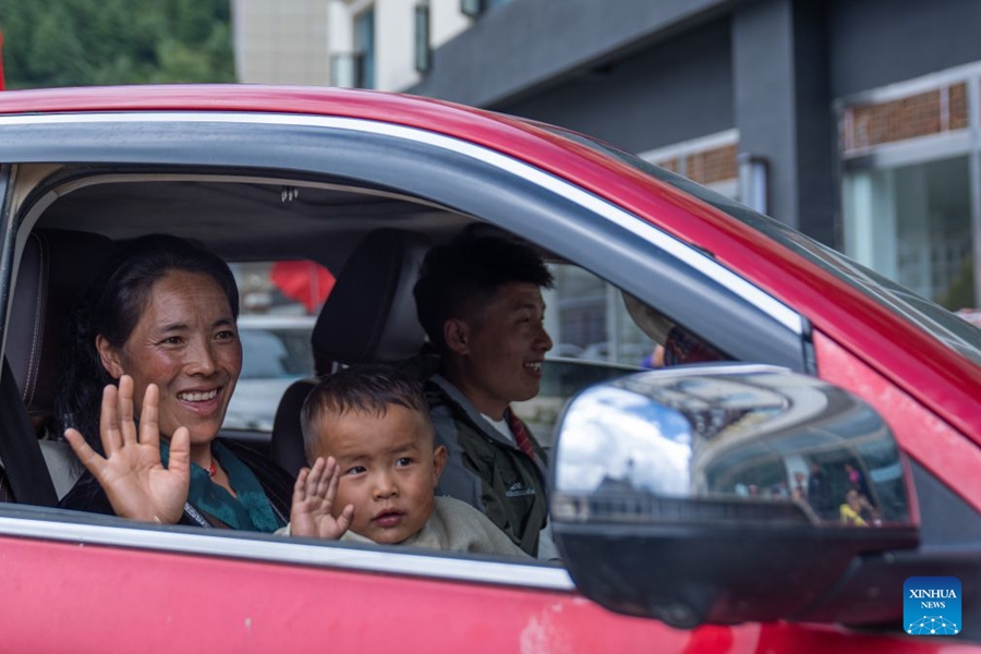 Persone nella zona colpita dalla colata di fango ritornano a casa a Gyirong, nello Xizang