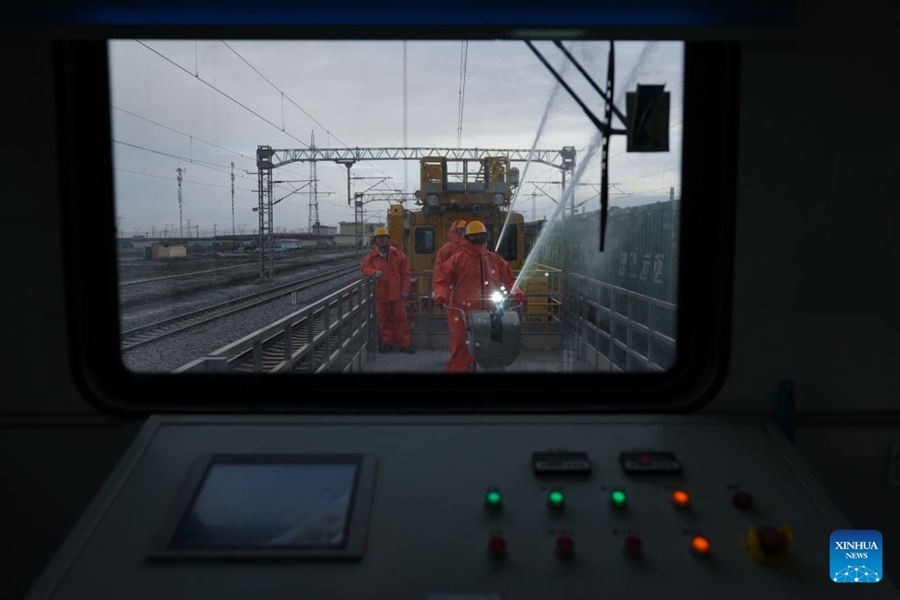 Operai puliscono gli isolatori della linea di contatto lungo la ferrovia Qinghai-Xizang