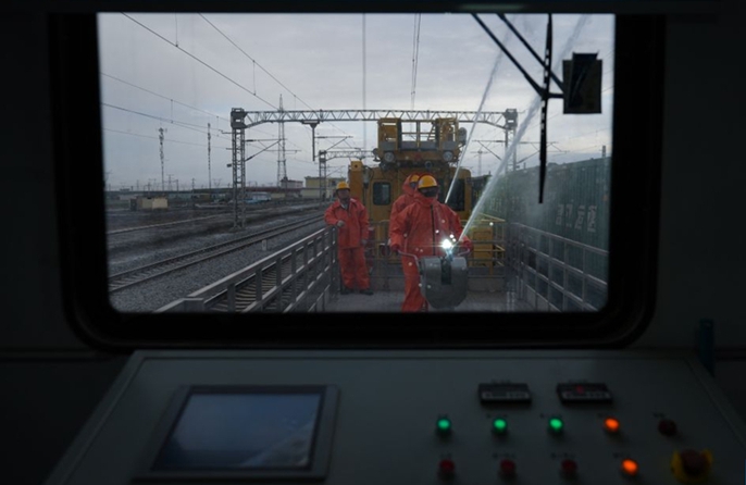Operai puliscono gli isolatori della linea di contatto lungo la ferrovia Qinghai-Xizang
