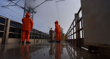 Operai puliscono gli isolatori della linea di contatto lungo la ferrovia Qinghai-Xizang
